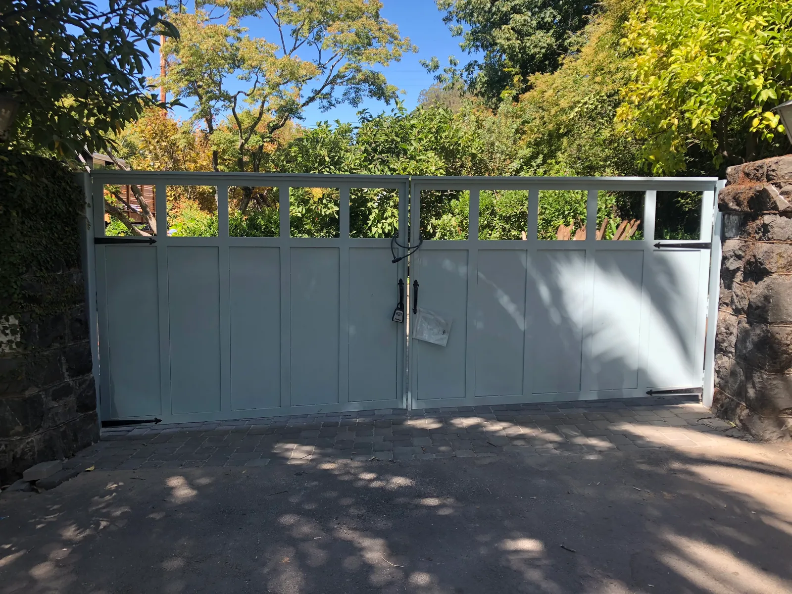 White automatic swing gate with gate operator on residential driveway