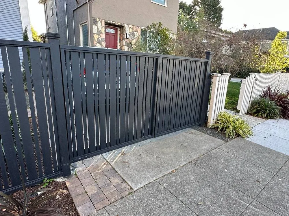 Black vertical slat driveway gate installation