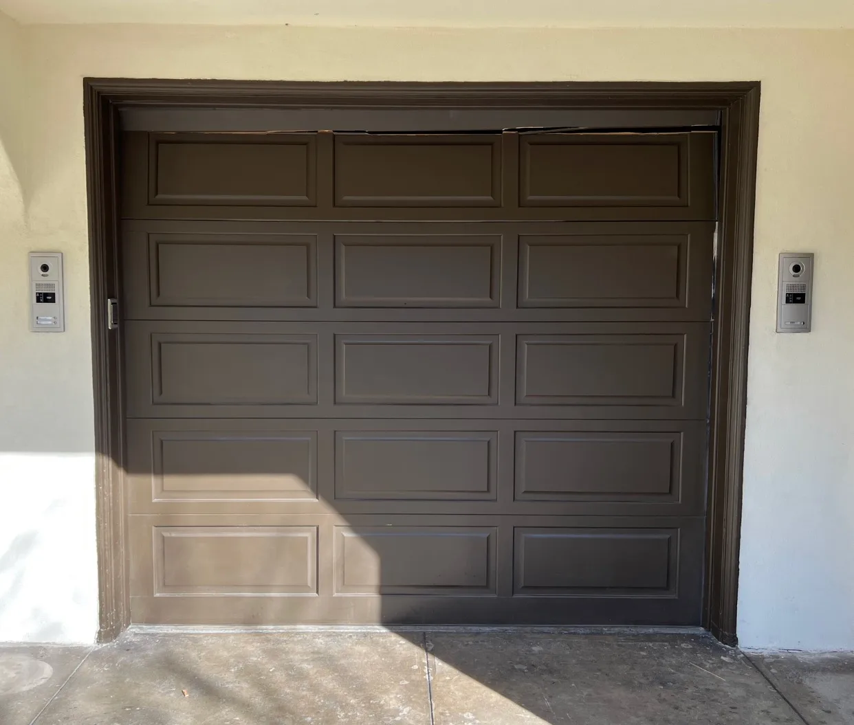 Brown raised-panel single-car garage door with keypad entry