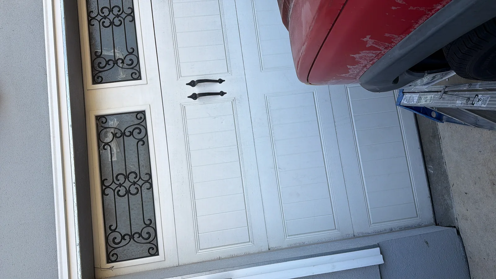 White carriage-style garage door with decorative wrought iron window inserts