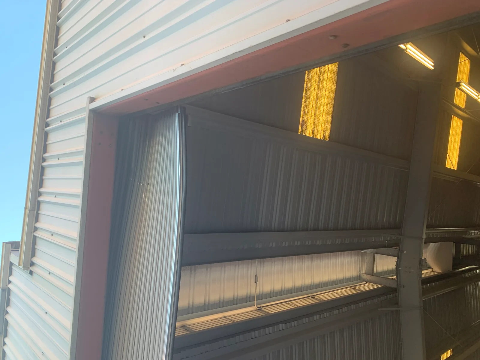 Damaged commercial roll-up garage door with bent panels