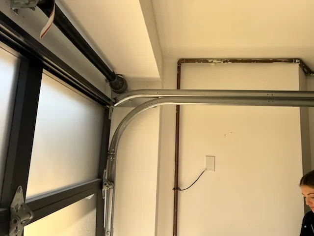 Interior view of garage door curved track, rollers, and hinges
