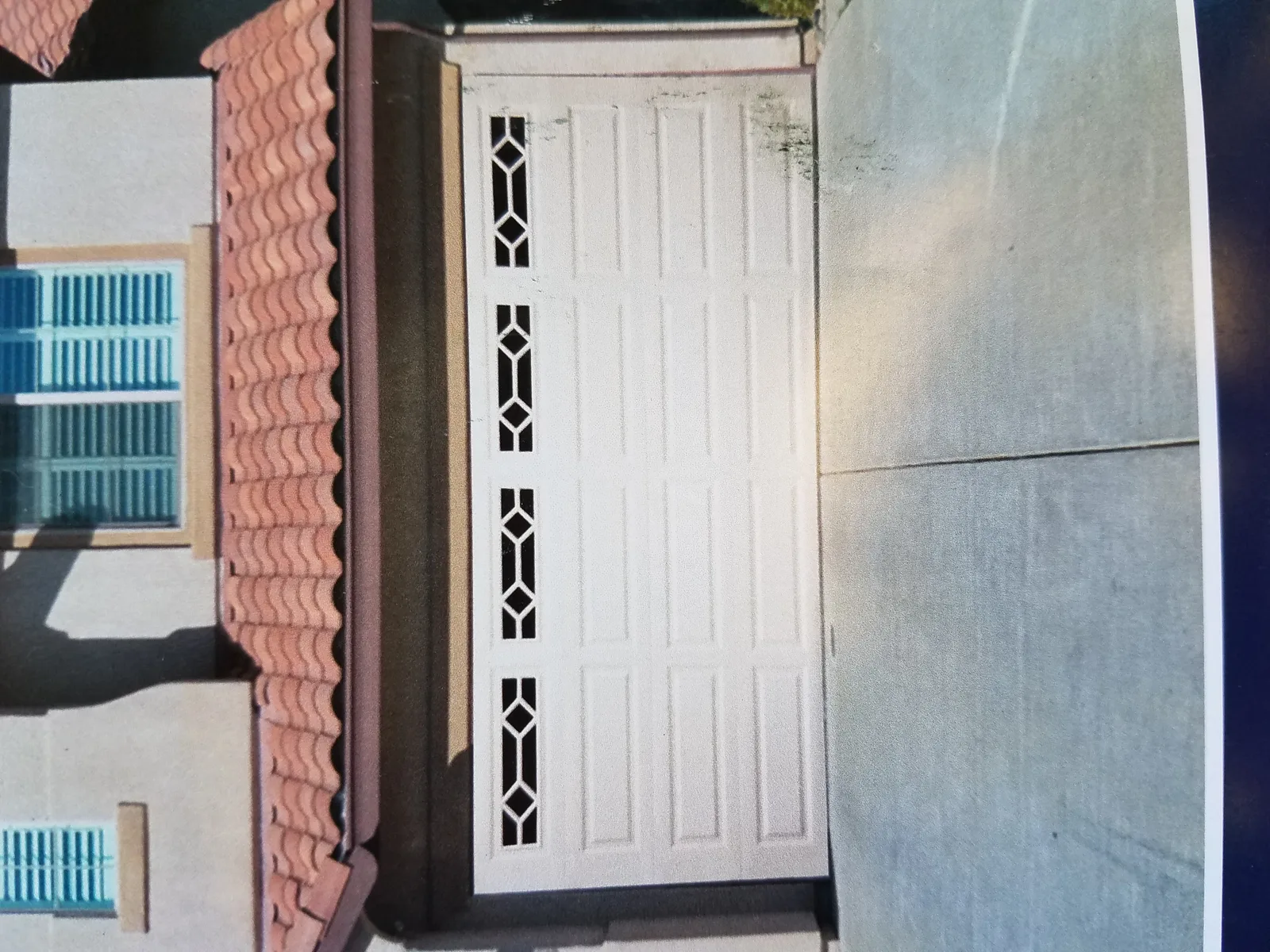White garage door with decorative diamond-pattern window inserts