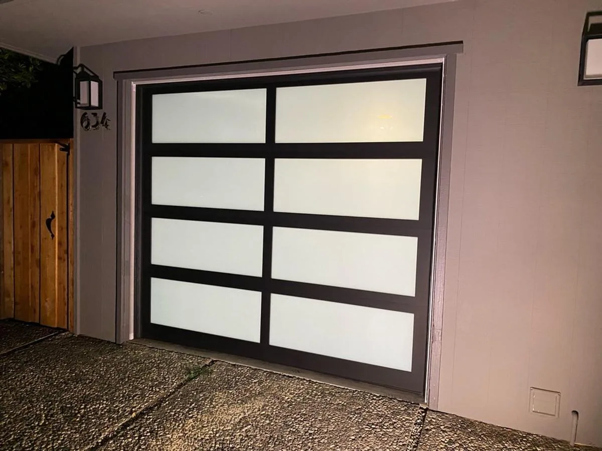 Full-view glass single car garage door at night