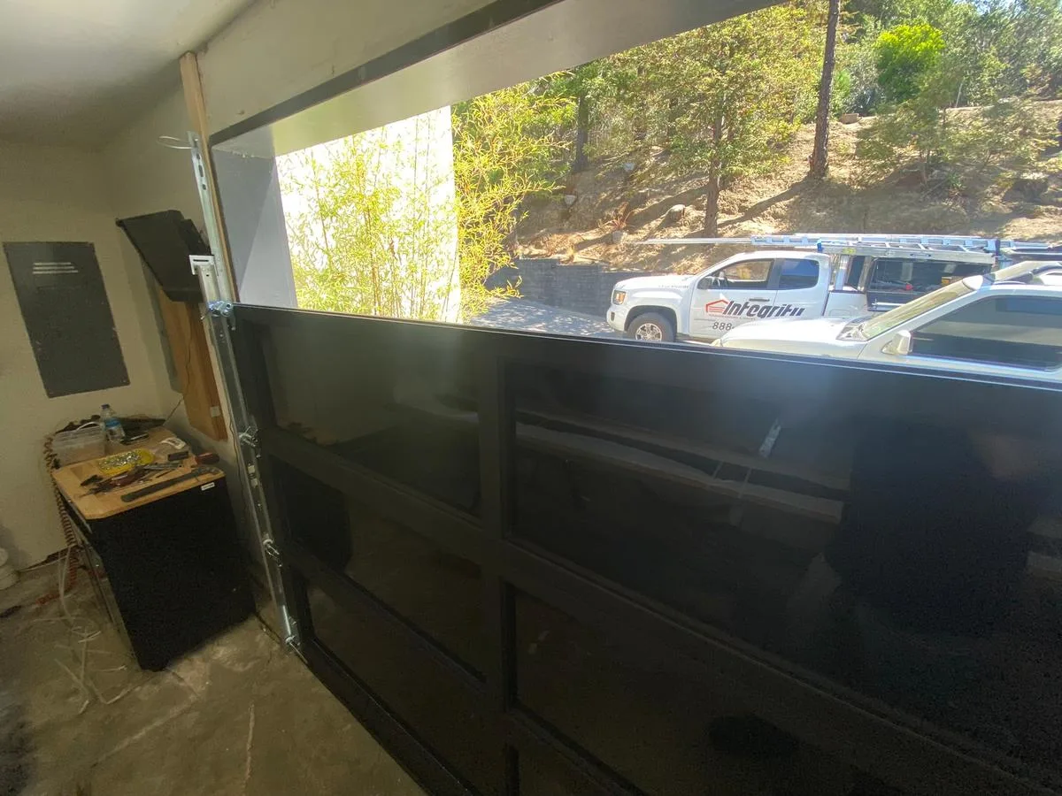 Glass garage door being installed with Integrity branded service truck