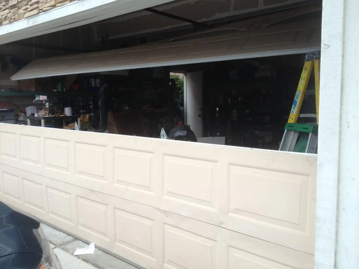 Garage door with buckled panels before repair