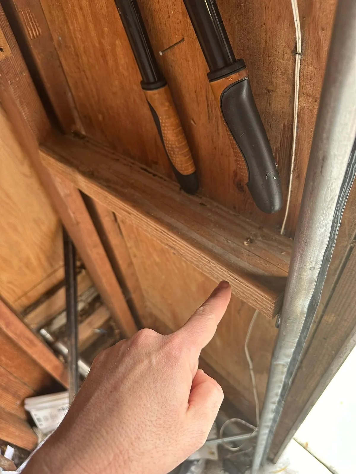 Garage door roller and hinge bracket being inspected for safety