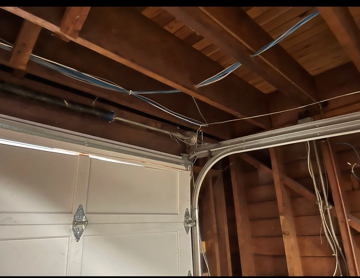 Looking up at garage door spring, torsion bar, and track system