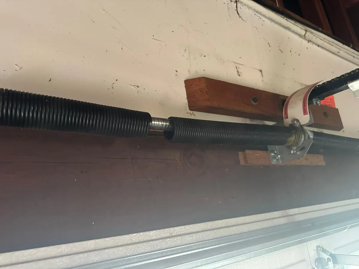 Close-up of torsion spring on garage door showing signs of wear