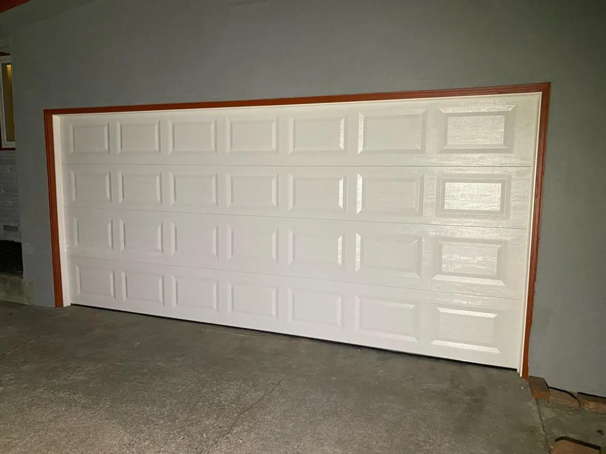 White raised panel garage door with wood trim accent